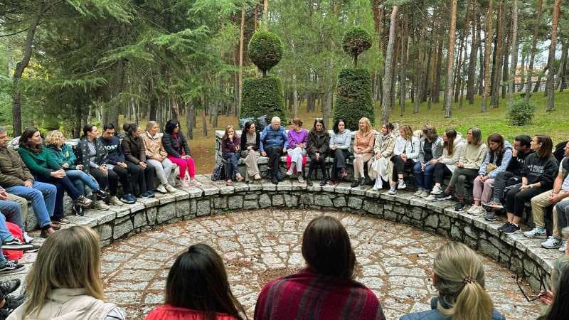 Participantes sentados en círculo en el anfiteatro de piedra del pinar